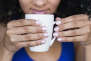 Close of multi racial hands holding a cup of coffee