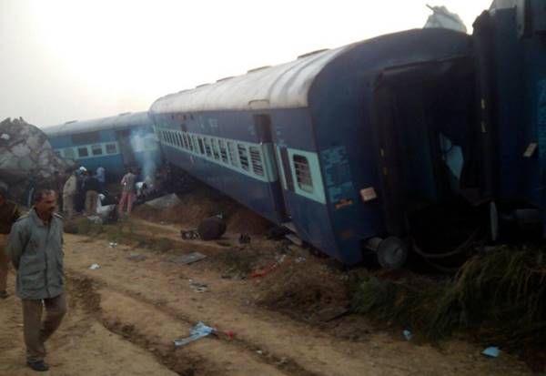 A man walks past the wreckage of an Indian train that derailed near Pukhrayan in Kanpur district on November 20, 2016. A passenger train derailed in northern India on November 20, killing at least 63 travellers most of whom were sleeping when the fatal accident occurred, police said. Rescue workers rushed to the scene near Kanpur in Uttar Pradesh state where the Patna-Indore express train derailed in the early hours of the morning.  / AFP PHOTO / -