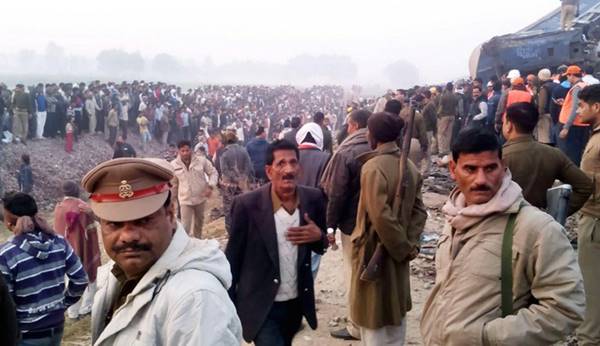 Onlookers and survivors gather next to wreckage of an Indian train that derailed near Pukhrayan in Kanpur district on November 20, 2016. A passenger train derailed in northern India on November 20, killing at least 63 travellers most of whom were sleeping when the fatal accident occurred, police said. Rescue workers rushed to the scene near Kanpur in Uttar Pradesh state where the Patna-Indore express train derailed in the early hours of the morning.  / AFP PHOTO / -