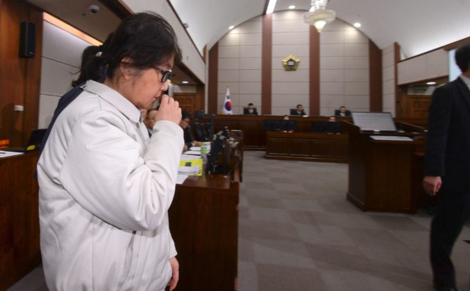 Choi Soon-Sil (L), who has been dubbed Korea's "female Rasputin" for the influence she wielded over the now-impeached president Park Geun-Hye, arrives at a courtroom for her trial at the Seoul Central District Court in Seoul on December 19, 2016. The woman at the centre of a corruption scandal that triggered the biggest political crisis for a generation in South Korea appeared in court on December 19 for a preliminary hearing in her trial on fraud charges. / AFP PHOTO / KOREA POOL / KOREA POOL / South Korea OUT